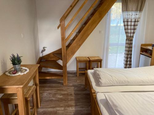 a room with two beds and a stair case at Székelyudvar Fogadó in Lukácsháza