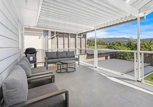 an outdoor patio with chairs and a grill at Sandy Dreams in Gerringong