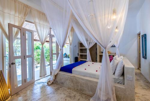 a bedroom with a bed with a mosquito net at Sharazad Oasis Retreat in Jambiani