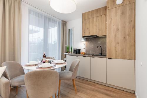 ミエルノにあるMielno Jantaris- Apartament B3- przy plażyのテーブルと椅子のあるキッチンとダイニングルーム