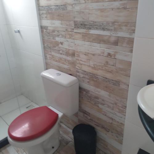 baño con aseo rojo y lavamanos en Alta baixa temporada, en Cabo Frío