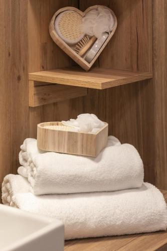 a bathroom with a shelf with towels and a heart at Mielno Jantaris- Apartament B3- przy plaży in Mielno