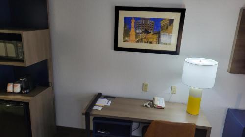 a desk in a hotel room with a lamp on it at Comfort Suites Macon Northwest in Macon