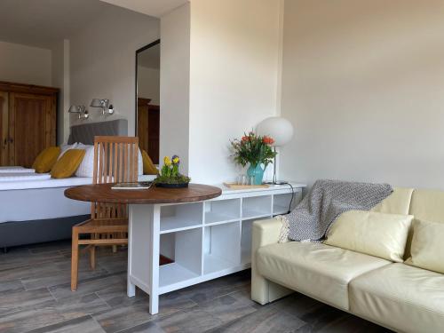 a living room with a couch and a table and a bed at Luisenhof in Neuglobsow