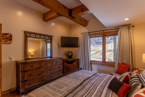 a bedroom with a bed and a dresser with a mirror at Mio Nido at Eagles Nest in Newland