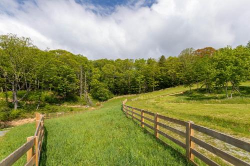 a wooden fence in a field with trees at Mio Nido at Eagles Nest in Newland