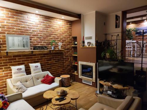 un soggiorno con un divano e un muro di mattoni di Dom Kowala a Jankowce