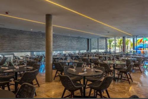 a restaurant with tables and chairs in a room at Salinas Premiun Resort Vista Mar ap1604 in Salinópolis