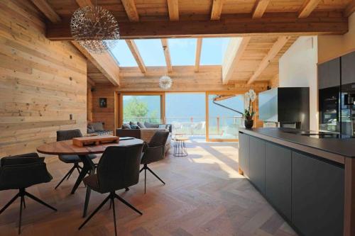 an open kitchen and living room with a table and chairs at Kitzbüheler Alpenpenthouse *private Sauna&Whirlpool* by STELLENBERG living in Hollersbach im Pinzgau