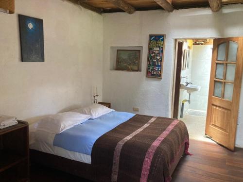 a bedroom with a bed and a bathroom with a sink at Hotel Ráquira Silvestre Lodge in Tinjacá