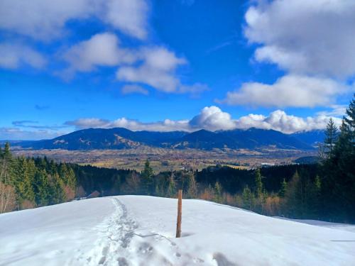 a snow covered hill with footprints in the snow at Ferienwohnung Geierstein in Wackersberg