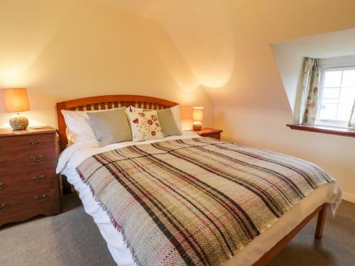 1 dormitorio con 1 cama, vestidor y ventana en Wyndhead Cottage, en Lauder