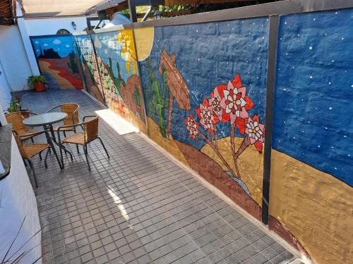 a mural on a wall with a table and chairs at PORTAL ANDINO in Godoy Cruz