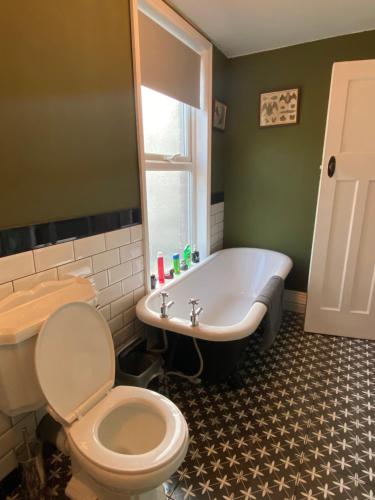 a bathroom with a tub and a toilet and a sink at Dracula Rooms in Whitby