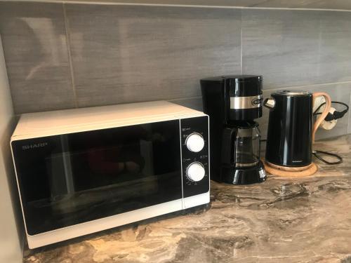 a microwave sitting on a counter next to a coffee maker at Apartament Vistula Centrum 4 in Wisła