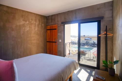 a bedroom with a bed and a balcony with a patio at Casas VV in Valle de Guadalupe