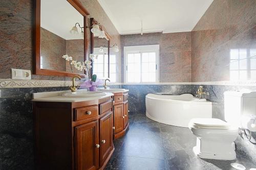 a bathroom with a tub and a sink and a toilet at Dúplex da Pedra e da Auga in Meis