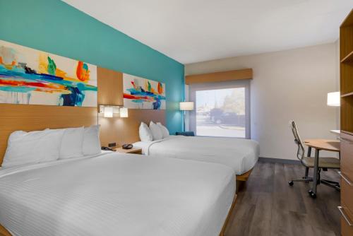 a hotel room with two beds and a desk at Best Western PLUS Executive Hotel Richmond in Richmond