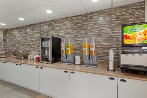 a kitchen with a counter with a television and drinks at Best Western PLUS Executive Hotel Richmond in Richmond
