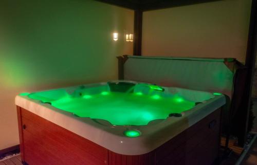 a bath tub with green lights in a room at Hiša Bohinc z wellnessom in Tolmin