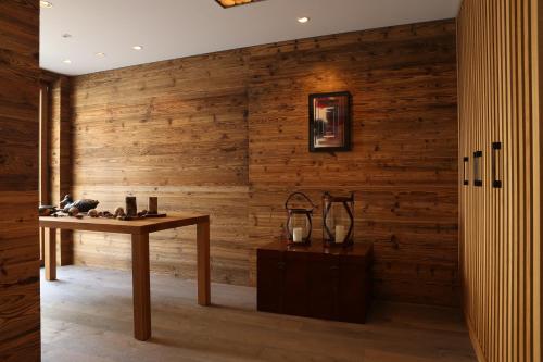 a room with a table and a wooden wall at The Capra Saas-Fee in Saas-Fee