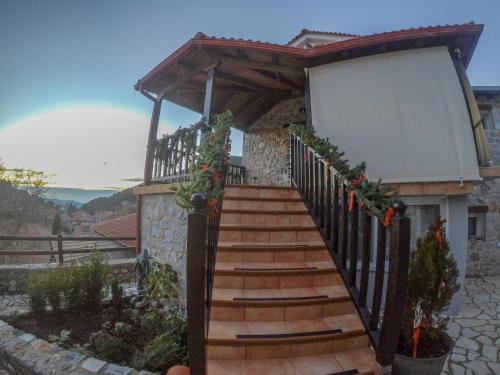 a wooden stairway leading up to a building with a gate at Ypsus House Stemnitsa in Stemnitsa