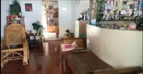 a living room with a wooden floor and a counter at Eastdee Homestay By Jaya in Lidlidda