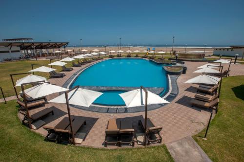 een zwembad met stoelen en parasols naast het strand bij DM Hoteles Asia in Asia