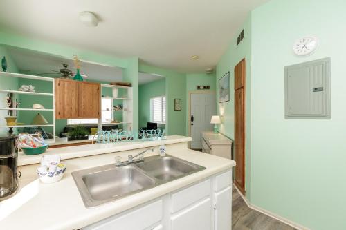 a kitchen with a sink and green walls at Corpus Christi-Padre Island condo is walking distance to beach by Mustang Island, Sleeps Four, 2024 Traveler Award in Padre Island