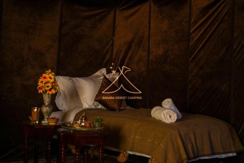 a bedroom with a bed with a wall at Sahara Desert Camping - Luxury Desert Camp Merzouga in Erfoud