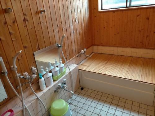 a bathroom with a tub and a toilet in it at Guesthouse Aozora - Vacation STAY 07229v in Myoko