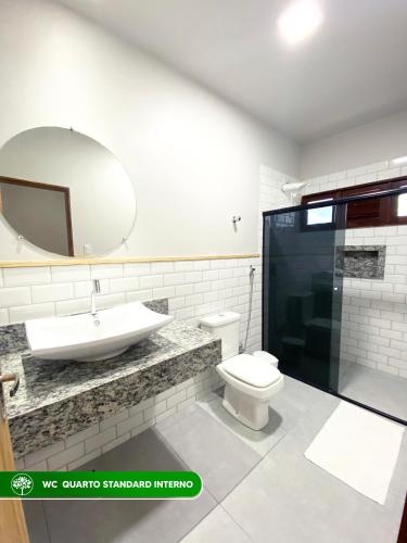 a bathroom with a sink and a toilet and a mirror at Pousada Estação Verde in Bonito
