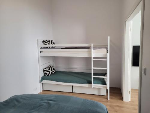 ein Schlafzimmer mit Etagenbetten in einem weißen Zimmer in der Unterkunft Apartmán VEJPRTY- Apartment WEIPERT in Vejprty