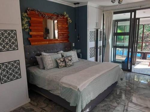 a bedroom with a large bed and a mirror at Tropical 4 Bedroom 3 bathroom 8 to 10 sleeper Holiday Getaway in Port Edward
