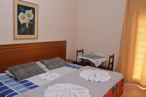 1 dormitorio con 2 camas y toallas. en HOTEL pousada CASARÃO, en Serra Negra