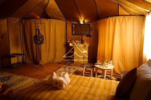 a bedroom with a bed with a teddy bear on it at Sahara Desert Camping - Luxury Desert Camp Merzouga in Erfoud