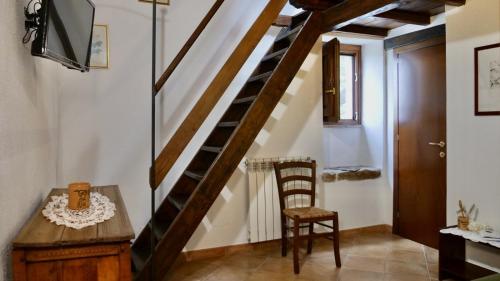 a staircase in a room with a table and a chair at Alle Vecchie Querce in Fontecchio