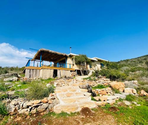 a house on the side of a hill with some rocks at Casa Sol in Clil