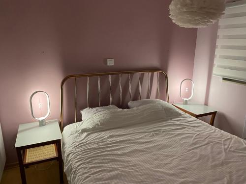 een slaapkamer met een bed met twee lampen op tafels bij Les Dunes Du Golf First Line Sea View App Block B 1-3 in Wimereux