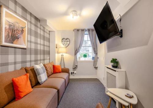 a living room with a couch and a flat screen tv at Townhouse Apartment 3 Bedroom High St Montrose in Montrose