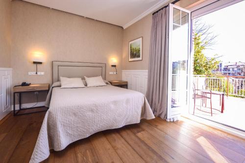 a bedroom with a bed and a large window at Hotel Alcazar Irun in Irún