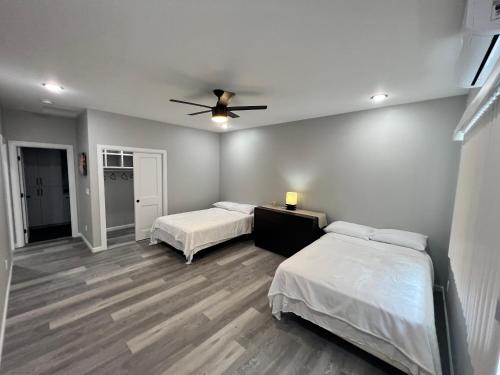 a bedroom with two beds and a ceiling fan at Beach Road Hale in Keaau