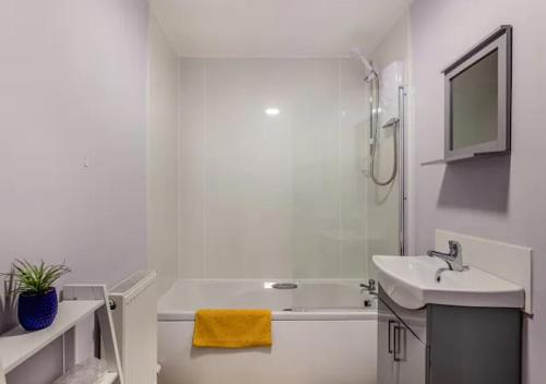 y baño blanco con lavabo, bañera y lavamanos. en Townhouse Apartment 3 Bedroom High St Montrose en Montrose