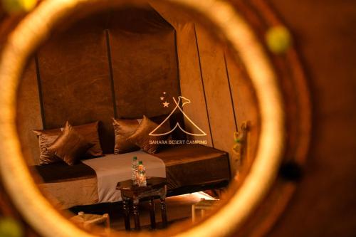 a view of a bedroom with a bed and a table at Sahara Desert Camping - Luxury Desert Camp Merzouga in Erfoud