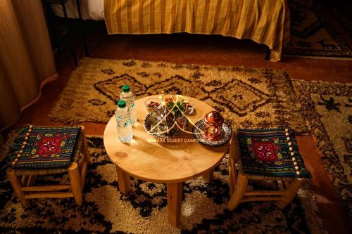 a table and two chairs in a living room at Sahara Desert Camping - Luxury Desert Camp Merzouga in Erfoud