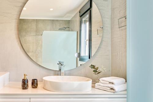 uma casa de banho com um lavatório e um espelho em Ligres Villa em Agia Paraskevi