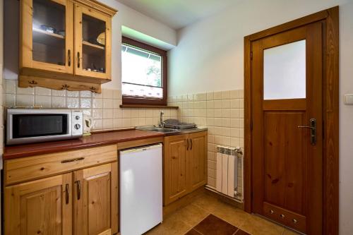 a kitchen with a white refrigerator and a microwave at Goga in Zakopane