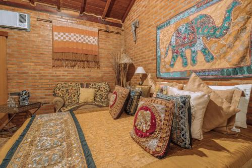 Habitación con cama con almohadas y mural en Pousada das Nascentes - Brotas, en Brotas
