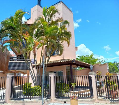 a house with palm trees in front of it at Orla Maria Apartamentos in Florianópolis