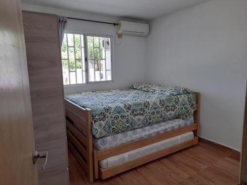 Schlafzimmer mit einem Bett und einem Fenster in der Unterkunft MY CASA BLANCA JF in Galapa